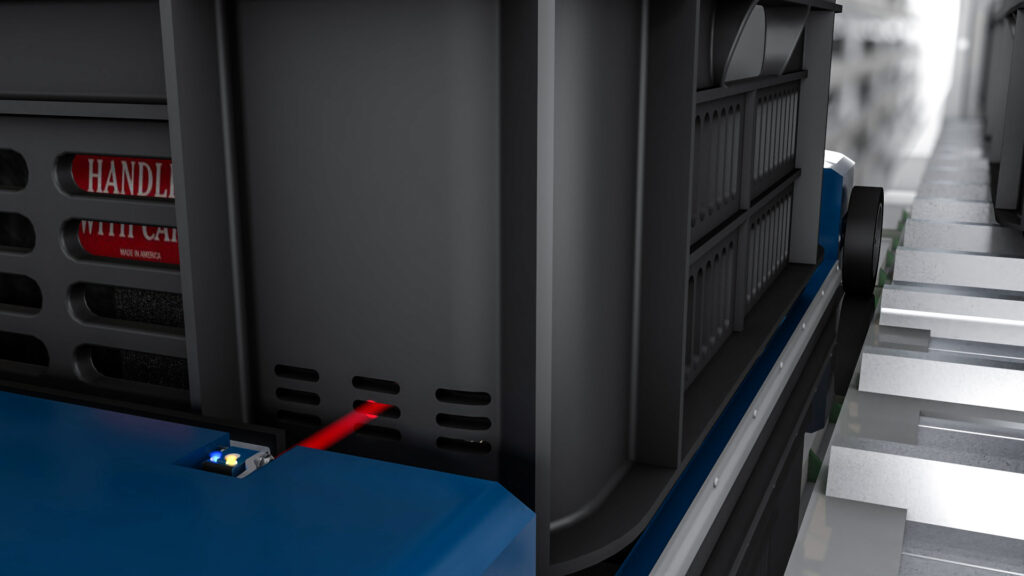 Reflextaster mit Hintergrundausblendung erkennt schwarze Kunststoffkisten auf einem Förderfahrzeug zuverlässig und positionsgenau.