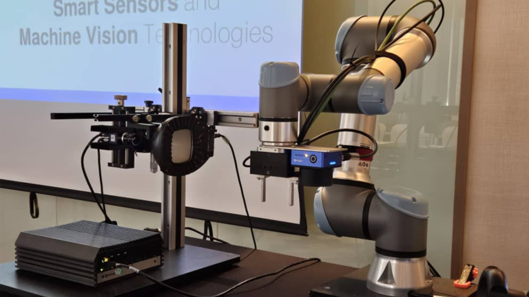 Robot UR s riadiacou jednotkou strojového videnia, kopulovým osvetlením a kamerou Smart Camera B60 v aplikačnej zostave.