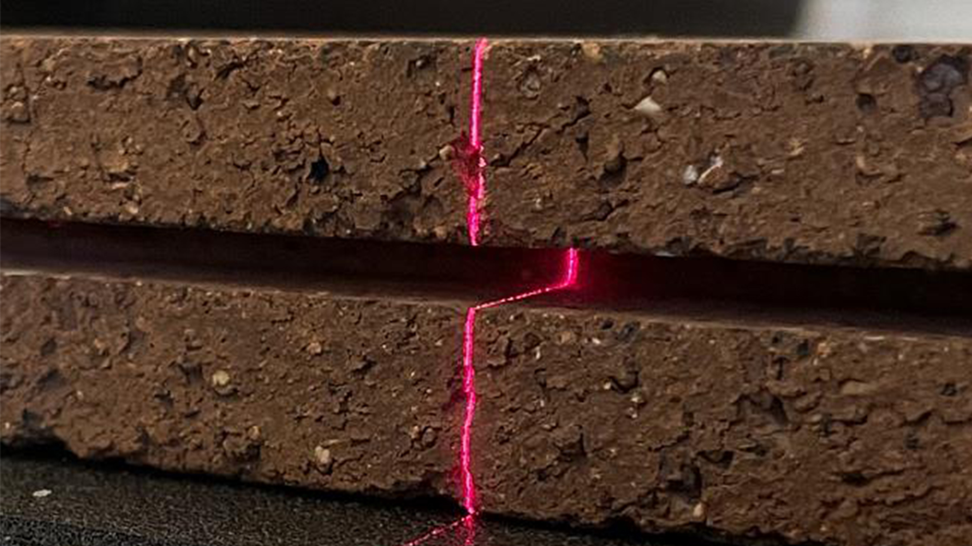 Línea láser en un ladrillo para medir la superficie